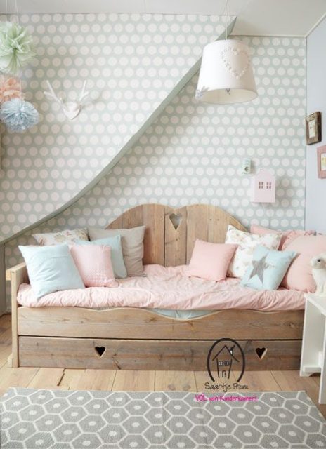 Divano letto in legno per la camera dei bambini con tessili dai toni delicati