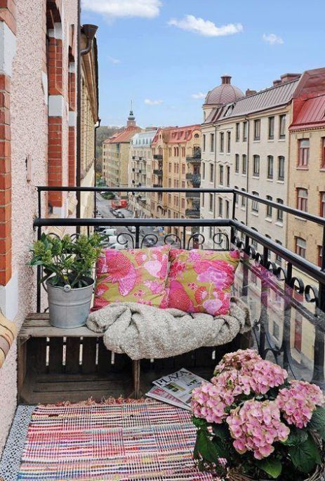 Balcone piccolo con fiori tappeto e cuscini rosa