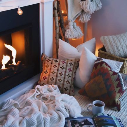 Un camino, cuscini, un tappeto, coperte e plaid per la casa invernale