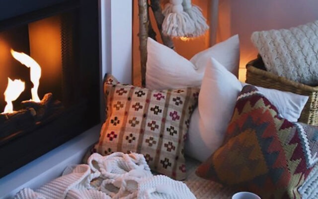 Un camino, cuscini, un tappeto, coperte e plaid per la casa invernale