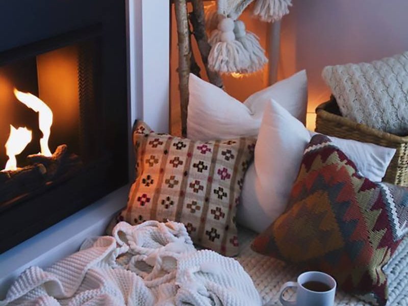 Un camino, cuscini, un tappeto, coperte e plaid per la casa invernale