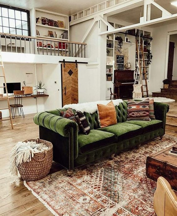 una casa industrial vintage con un bellissimo divano in velluto verde