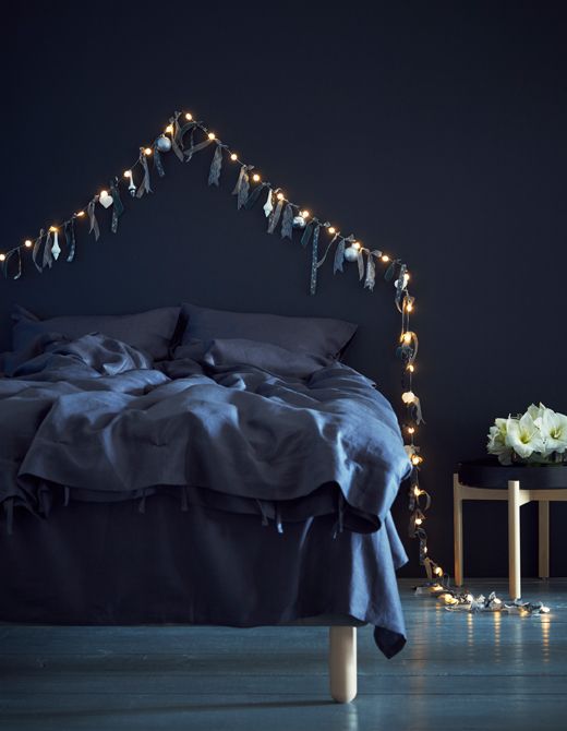 Camera da letto dai toni del blu con una semplice ghirlanda dorata a creare la perfetta atmosfera natalizia