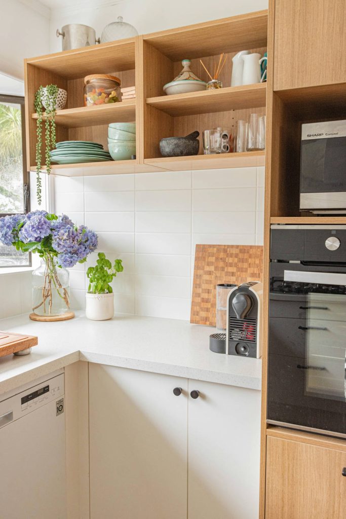 Styling estivo in cucina con vaso di vetro erbe aromatiche e fiori freschi